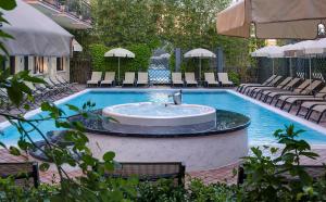 a swimming pool with a fountain in the middle at Palace Hotel San Pietro in Bardolino