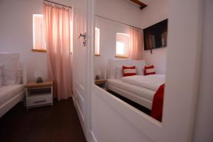 a small bedroom with two beds and a mirror at Willa Starowiejska in Racibórz