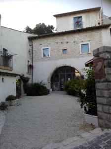 duży kamienny budynek z dużymi drzwiami w obiekcie Residenza Storica le Civette w mieście Castel del Monte