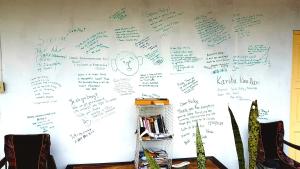 a wall covered with writing on a wall at Casa Ricky's in Orange Walk