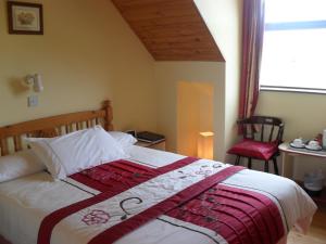 um quarto com uma cama com um cobertor vermelho e branco em Melrose B&B em Clonakilty