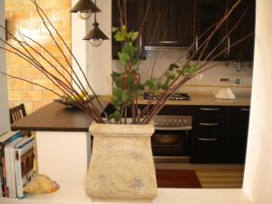 a vase with branches in it on a kitchen counter at Cantinho do Céu in Vila Real de Santo António