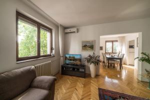 uma sala de estar com um sofá e uma televisão de ecrã plano em Sensitive Apartment em Belgrado