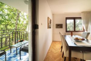 uma cozinha e sala de jantar com uma mesa e uma varanda em Sensitive Apartment em Belgrado