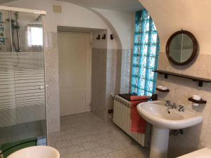 a bathroom with a sink and a shower and a mirror at Ammoglja in Calascio
