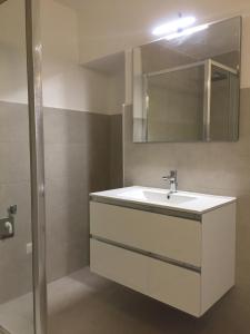 W łazience znajduje się biała umywalka i lustro. w obiekcie Conte Spada Home w mieście Nardò