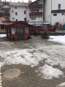 a small building in a parking lot with snow at Spa-ul Schiorilor in Predeal