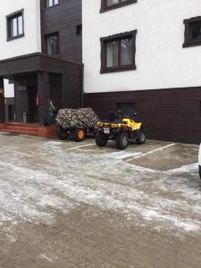 due quad parcheggiati in un parcheggio accanto a un edificio di Spa-ul Schiorilor a Predeal