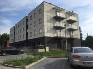 budynek z samochodami zaparkowanymi przed nim w obiekcie Apartament Antek klimatyzowany w Oświęcimiu