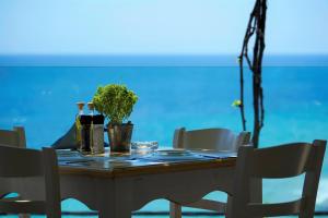 a wooden table with chairs and a table with plants on it at Agorastos Hotel in Koinyra