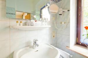 bagno con lavandino e specchio di Hotel Bockelmann a Bispingen
