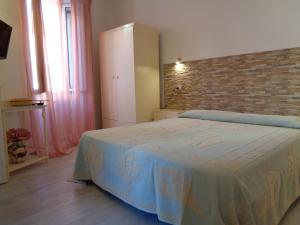1 dormitorio con cama y pared de ladrillo en Sardinia-holiday B&B Spargi, en La Maddalena