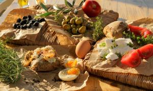 two slices of bread with eggs and vegetables on a table at Agorastos Hotel in Koinyra