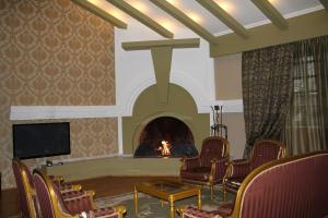 Habitación con chimenea, sillas y TV. en Prestige Palace - Esquisse Hotel, en Tiflis