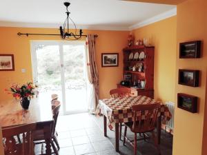 a dining room with a table and chairs and a window at Dunlewey Lodge - Dunlewey, Gweedore in Gweedore