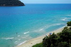 a beach with people on the sand and the ocean at Agorastos Hotel in Koinyra