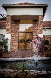 a fire hydrant in front of a brick building at Guesthouse Serenity in Hartbeespoort