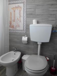 a bathroom with a white toilet and a sink at Vivenda Familia Pedro in Vila do Bispo