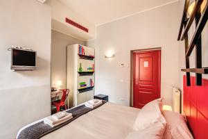 a small bedroom with a bed and a red door at Milazzo23 in Rome