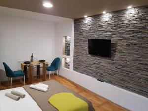 a living room with a brick wall with a tv at Woodstone apartment in Ploieşti