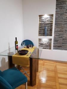 a dining room with a glass table and a bottle of wine at Woodstone apartment in Ploieşti