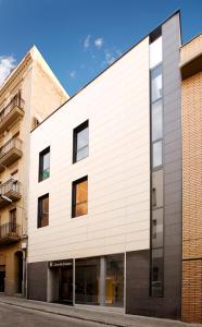 un edificio blanco con ventanas de cristal en una calle en Live & Dream, en Barcelona