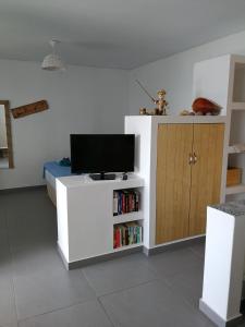 a living room with a tv on a white cabinet at Christou Homes in Steni Vala Alonissos