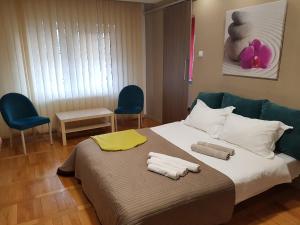 a bedroom with a bed with towels on it at Woodstone apartment in Ploieşti