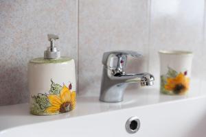 lavabo con grifo y soporte para flores en Berici Bed and Breakfast, en Nanto