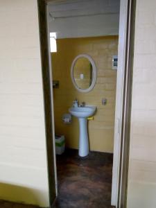 een badkamer met een wastafel en een spiegel bij Chalet Suizo in Pachacamac