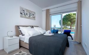 a bedroom with a bed and a large window at Villa Moderna Family Friendly in Hvar