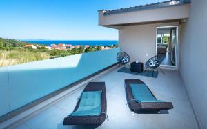 a balcony with two lounge chairs and the ocean at Villa Moderna Family Friendly in Hvar +42 photos