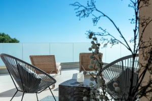 a patio with two chairs and a table with a vase at Villa Moderna Family Friendly in Hvar