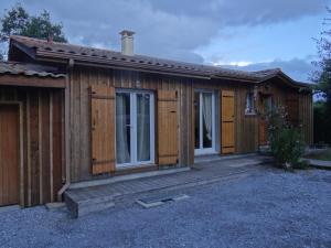 een houten hut met een veranda en een deur bij comme chez vous in Taussat-les-Bains