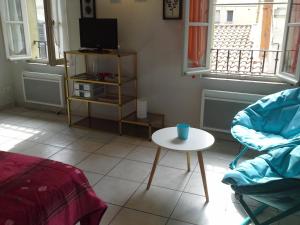 uma sala de estar com uma mesa e uma televisão em Appartement Terrasse - Hypercentre em Avignon