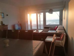 a living room with a couch and a view of the ocean at appartement zeedijk westende in Middelkerke
