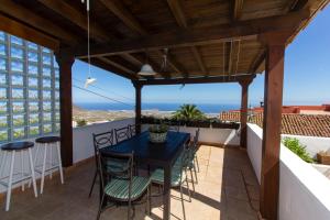 a patio with a blue table and chairs on a balcony at Varanski Vista in San Miguel de Abona