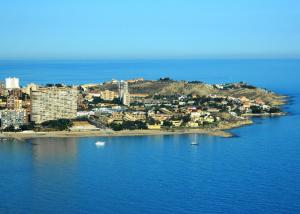 an island in the ocean with boats in the water at Hotel Boutique Calas de Alicante in Alicante