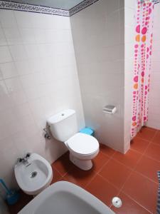 Un baño con un inodoro blanco y un lavabo. en Casa Azul, en Nazaré