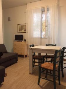 a living room with a table and chairs and a couch at CasaLella in Viareggio
