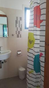 a bathroom with a sink and a shower curtain at Esperides in Batsi