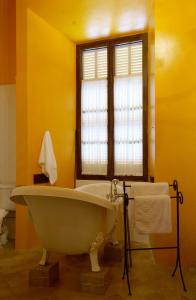 a bath tub in a yellow bathroom with a window at Palacio Sant Salvador in Artá +45 photos