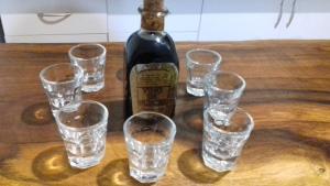 a bottle of wine and glasses on a wooden table at La María de Tortas in Paterna del Madera