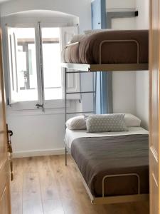 a bedroom with two bunk beds and a window at Vilamarlux II in Vilassar de Mar