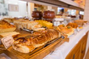 a display case with various types of bread and pastries at Pousada Piano Piano in Campos do Jordão