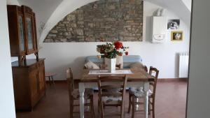 uma sala de jantar com uma mesa com um vaso de flores em La casina negli orti em Arcola