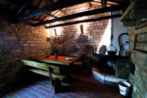 a room with a wooden table and a brick wall at Traditional Istrian Stone House in Šmarje