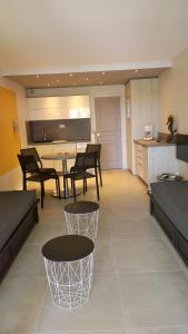 a living room with a table and chairs and a kitchen at Les Rivages des Issambres in Les Issambres