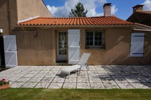 a white chair sitting in front of a house at La Bourie in Le Girouard
