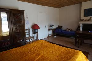 a bedroom with a bed and a table and a chair at La Bourie in Le Girouard